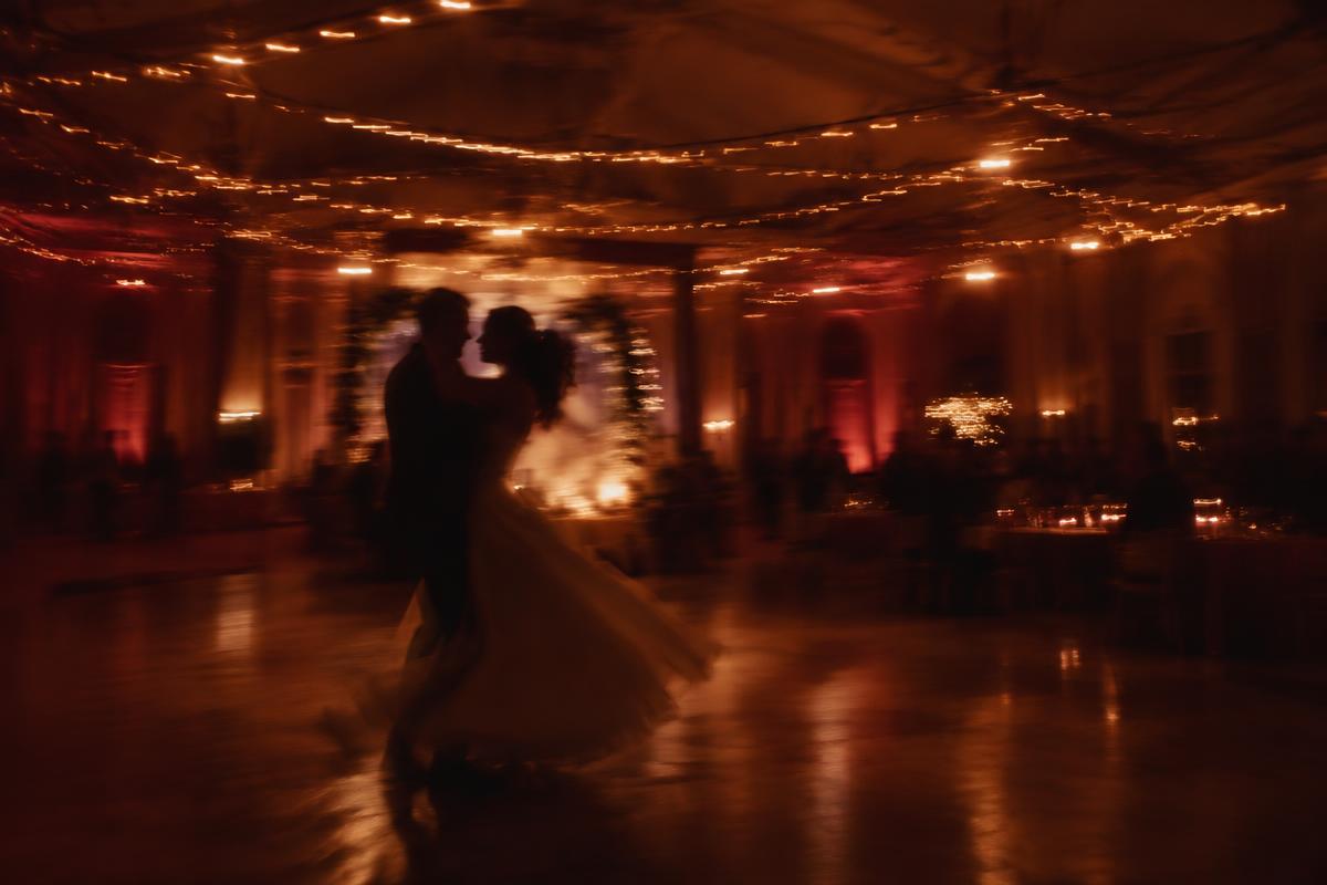 First dance under warm string lights in an elegant ballroom